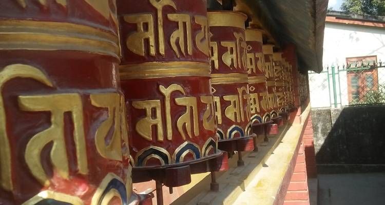 Nahaufnahme von bunten Gebetsmühlen, die mit Text bemalt sind.