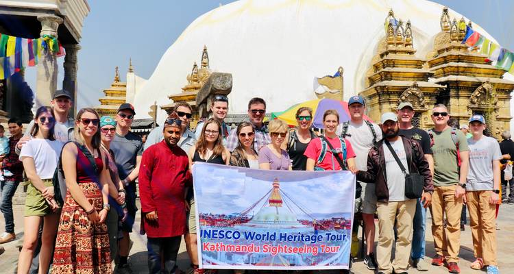 Groepsfoto voor een stupa met een toerbanner.