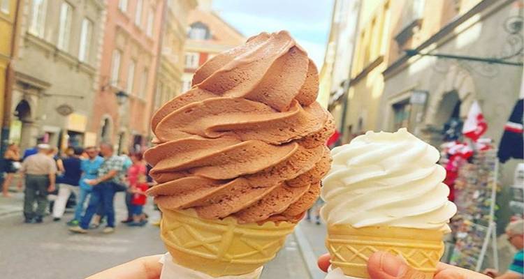 Dos grandes conos de helado levantados en una calle concurrida.
