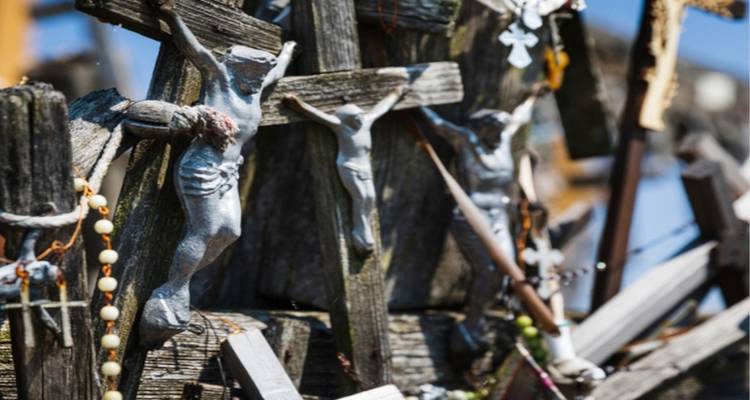 Colección de cruces y símbolos religiosos en una estructura de madera.