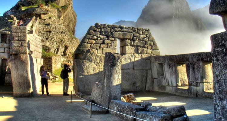 Stenen structuren met mist en bergachtige achtergrond.