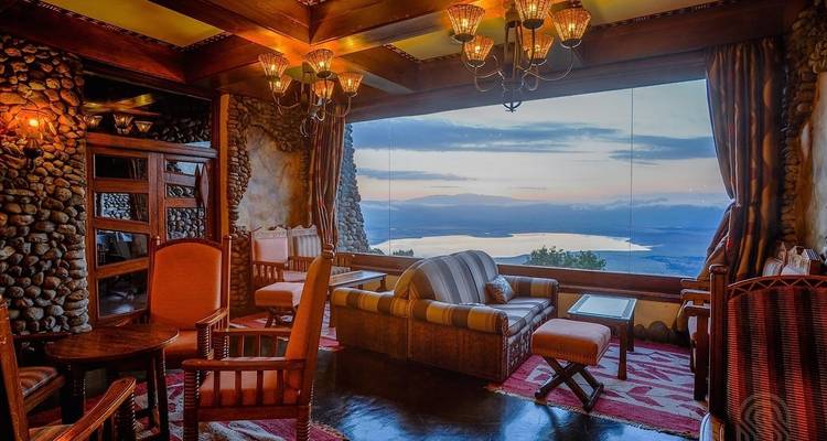 Luxurious lodge interior with a view of a lake and mountains.