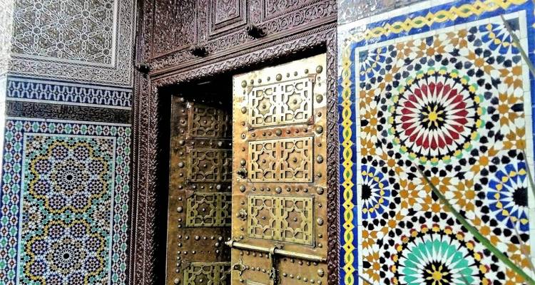 Mur de mosaïque complexe et une porte en bois.