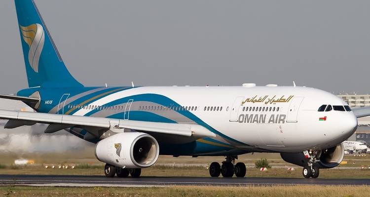 Avión de Oman Air estacionado en una pista.
