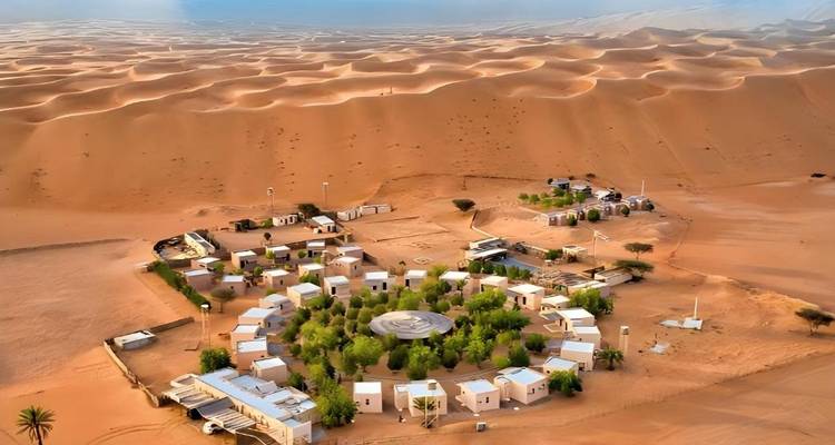 Una vista aérea de un campamento en el desierto con dunas de arena circundantes.