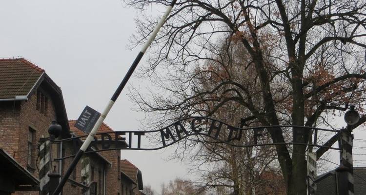 Portail d'entrée d'un camp de concentration avec l'inscription « Arbeit Macht Frei ».