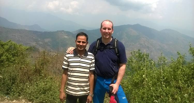 Twee mensen poseren voor een bergachtig landschap.