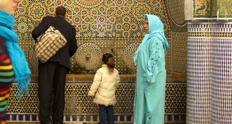 People observing intricate mosaic tiles.