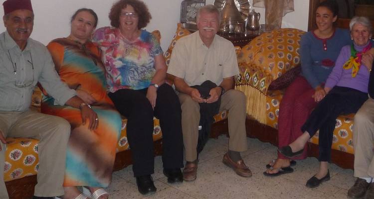 Group of people sitting together, smiling at the camera.