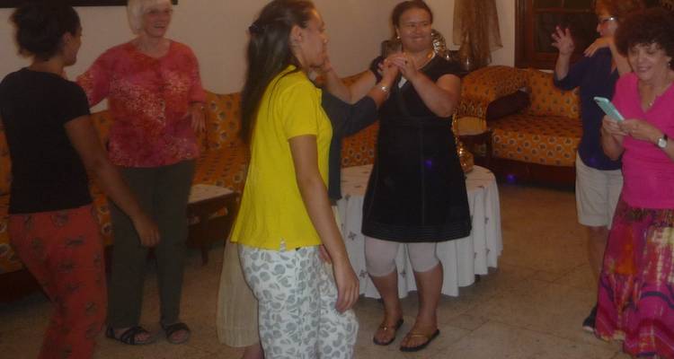 Group of people holding hands and dancing indoors.