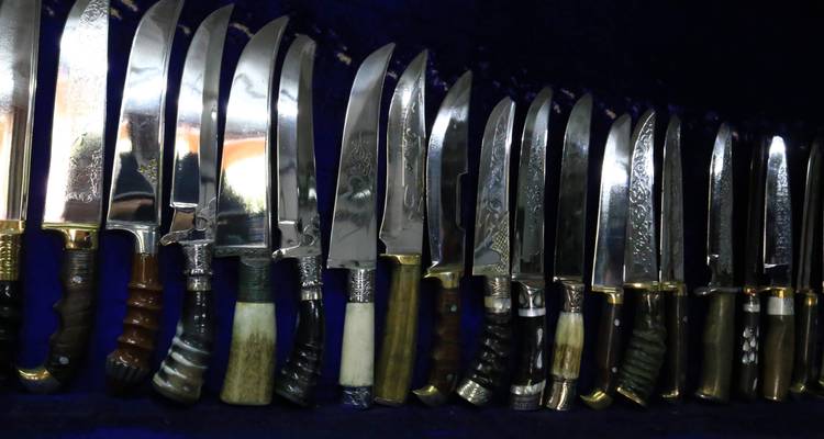 Assortiment van messen uitgestald op een stoffen oppervlak.