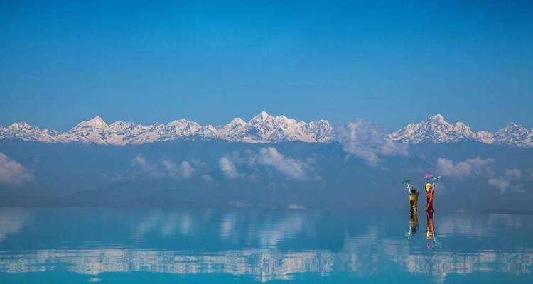 Stunning view of snow-capped mountains reflected in a calm lake.