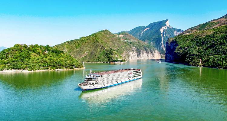 Grand navire de croisière sur une rivière entourée de collines
