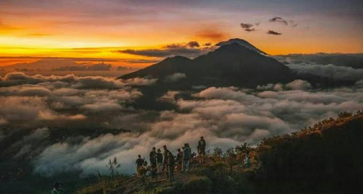 People enjoying sunrise with mountains in the background.