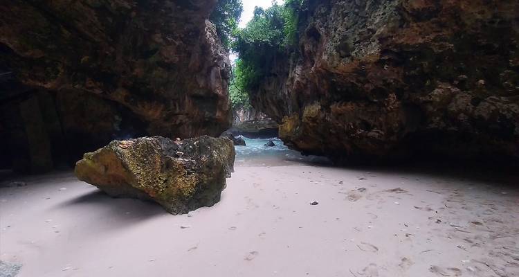 Sandy beach surrounded by large rock formations.
