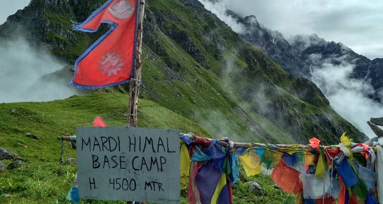 View of Mardi Himal Base Camp with prayer flags and mountainous backdrop.