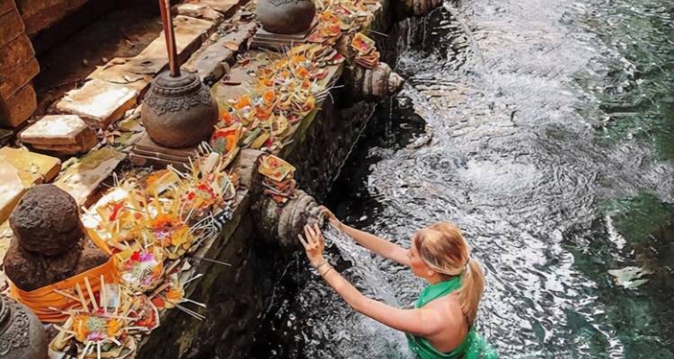 Mujer rubia realizando un ritual en un santuario de agua.