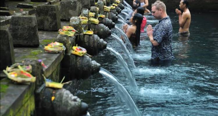 Grupo de personas participando en un ritual de agua en un templo.