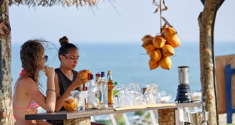Deux femmes dans un bar de plage avec des noix de coco.