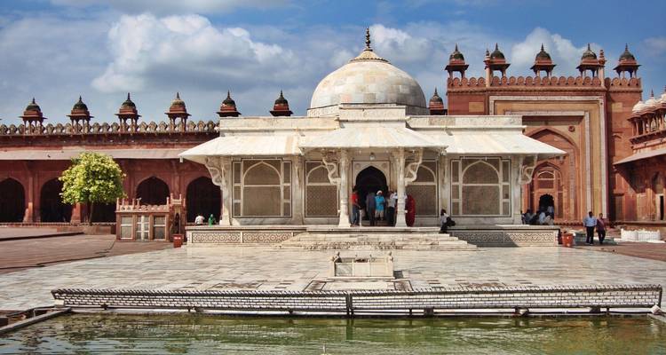 Tombeau de marbre orné dans une cour historique.
