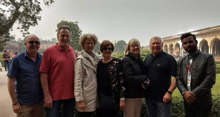 Photo de groupe de sept personnes à l'extérieur près d'un jardin.