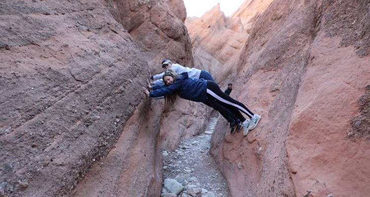 Deux personnes s'accrochant aux parois du canyon dans un passage étroit.