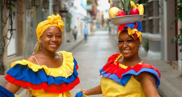 Dos mujeres con atuendo tradicional colorido en una calle.