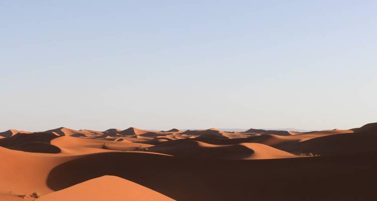 Weite Wüstenlandschaft mit Sanddünen.