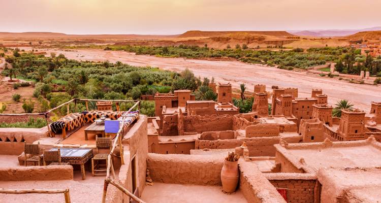 Alte Stadt mit einem Fluss und Wüstenlandschaft.