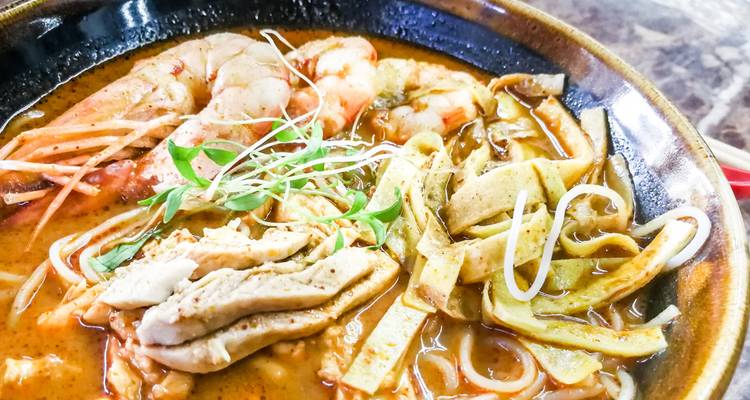 Nahaufnahme einer Schüssel Nudelsuppe mit Garnelen und Hähnchen.
