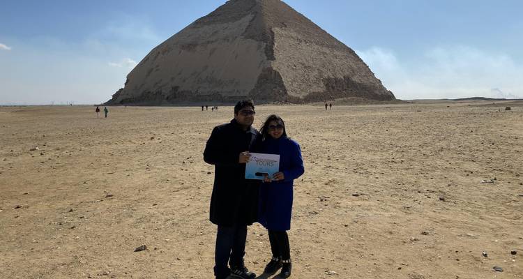 Two people standing in front of the Bent Pyramid in Egypt.