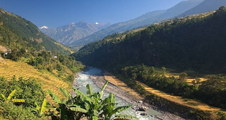 Rivier die door een vallei stroomt, omringd door bergen.