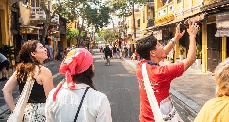 Toeristen die een straat verkennen met traditionele gebouwen.