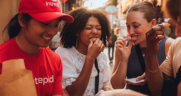 Des amis dégustant de la nourriture de rue ensemble dans une ruelle de marché animée