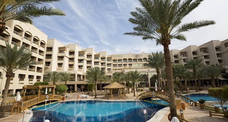 Ein Resort mit einem Pool und Palmen, das eine luxuriöse Umgebung bietet.