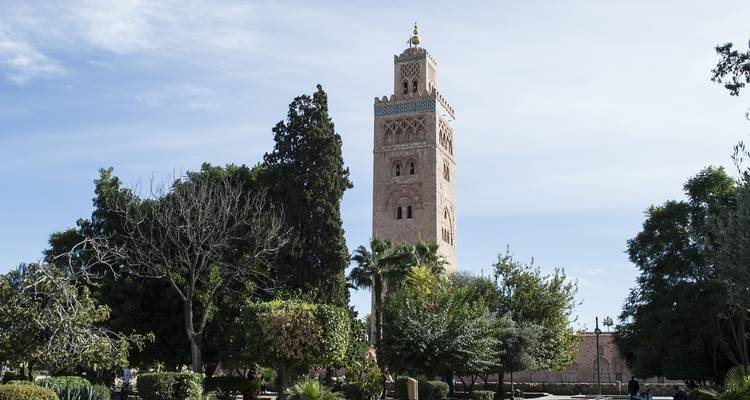 Mosquée Koutoubia avec des arbres luxuriants sous un ciel dégagé.