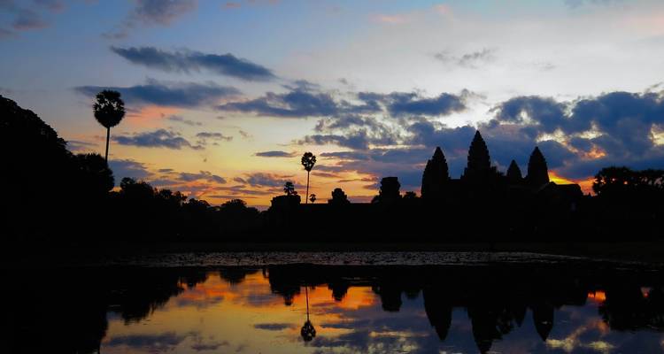 "Silhouette d'Angkor Vat au coucher du soleil avec reflet."