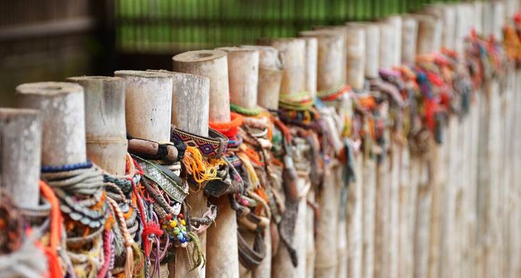 Rows of bamboo posts covered with colorful friendship bracelets at the Killing Fields memorial