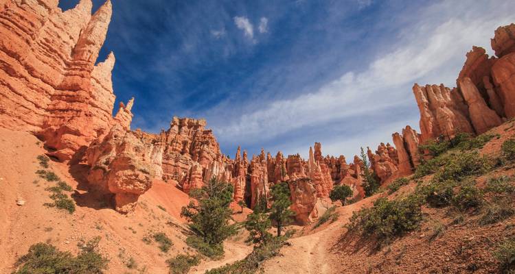 Les aiguilles de hoodoo de couleur rouille s'élèvent dramatiquement sous un ciel vibrant