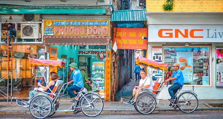 Mensen die in riksja's rijden in een stedelijke straatomgeving.