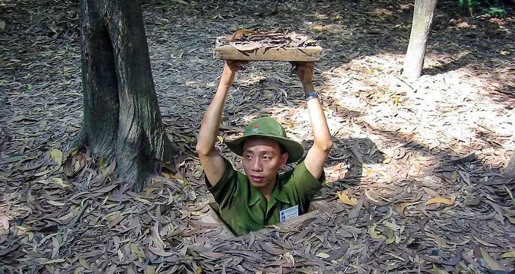 Man die uit een tunnel in een jungleomgeving tevoorschijn komt.