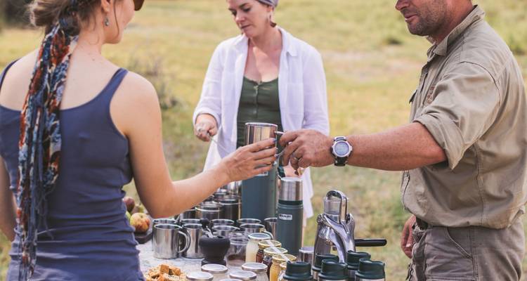 Group of people enjoying a picnic with cups and plates.