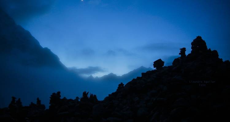 Silhouette sombre et brumeuse de pierres empilées contre un ciel bleu