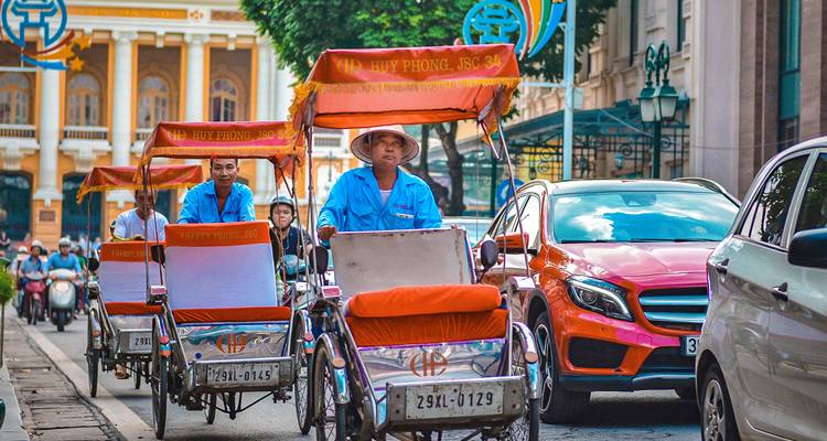 Cyclo drivers navigating a busy street.