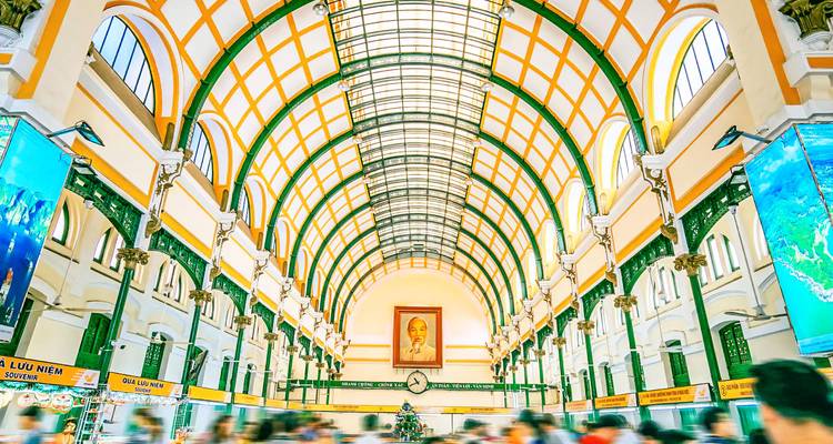 Innenraum eines prächtigen Gebäudes mit gewölbten Decken und gehenden Menschen.