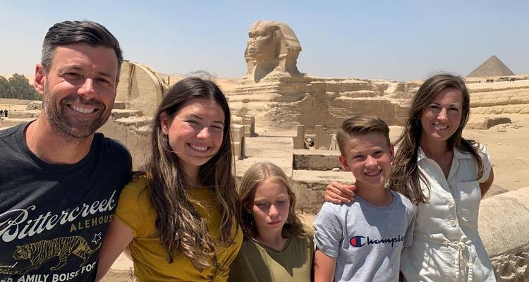 Family posing with the Sphinx and pyramids in the background.