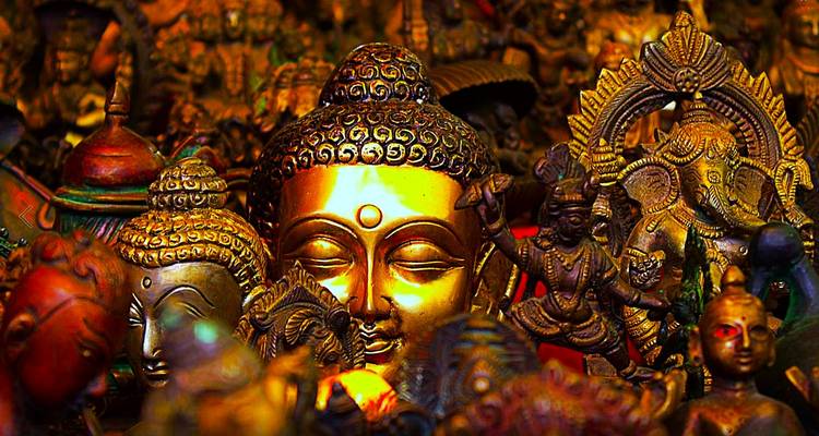 Verschiedene Statuen mit Fokus auf einem goldenen Buddha.