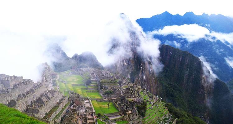 Malerischer Blick auf Machu Picchu, teilweise von Nebel und Wolken bedeckt.