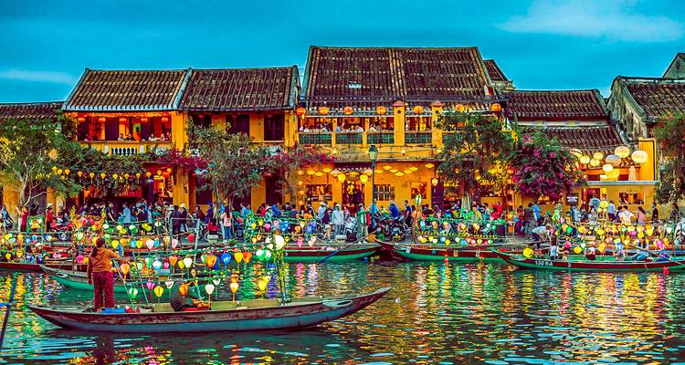 Una vibrante escena de mercado nocturno con botes y faroles en el río.