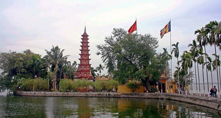 Schilderachtig tempelcomplex met grote vijver en vlaggen.